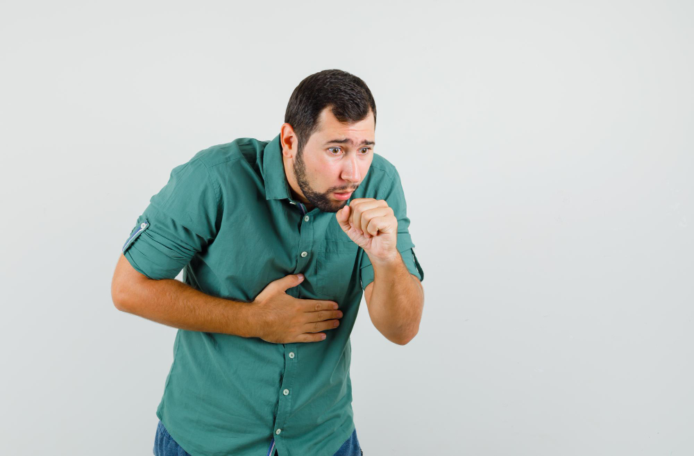 young-male-green-shirt-coughing-looking-uncomfortable-front-view